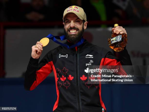 Charles Hamelin of Canada holds up his gold medal after finishing first in the men's 1000 meter Final during the World Short Track Speed Skating...