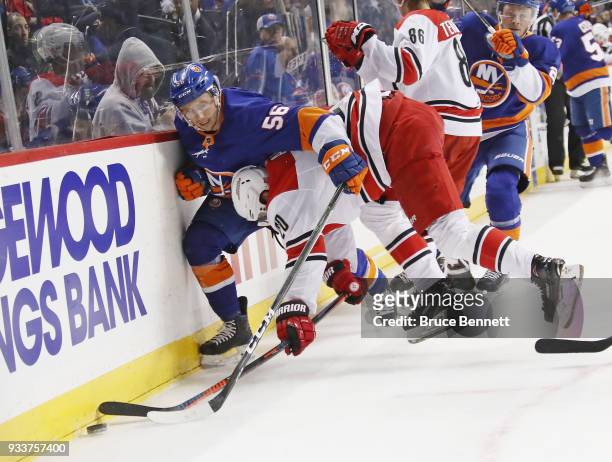 Tanner Fritz of the New York Islanders and Sebastian Aho of the Carolina Hurricanes battle along the boards during the second period at the Barclays...