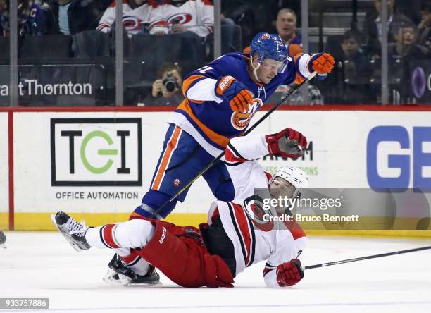 Chris Wagner of the New York Islanders trips up Brett Pesce of the Carolina Hurricanes during the second period at the Barclays Center on March 18,...