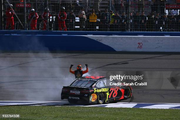 Martin Truex Jr., driver of the Bass Pro Shops/5-hour ENERGY Toyota, celebrates after winning the Monster Energy NASCAR Cup Series Auto Club 400 at...