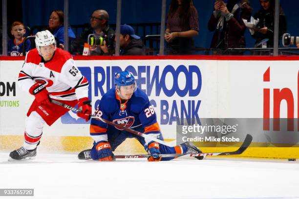 Jeff Skinner of the Carolina Hurricanes and Sebastian Aho of the New York Islanders eye a loose puck during the second period at Barclays Center on...