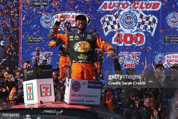 Martin Truex Jr., driver of the Bass Pro Shops/5-hour ENERGY Toyota, celebrates in victory lane after winning the Monster Energy NASCAR Cup Series...