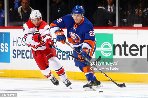 Sebastian Aho of the New York Islanders passes the puck amid pressure from Sebastian Aho of the Carolina Hurricanes during the third period at...