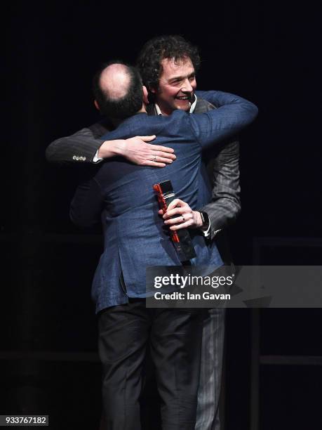 Comedian Chris Addison presents actor Armando Iannucci with the award for Best Comedy for 'Death of Stalin', on stage during the Rakuten TV EMPIRE...