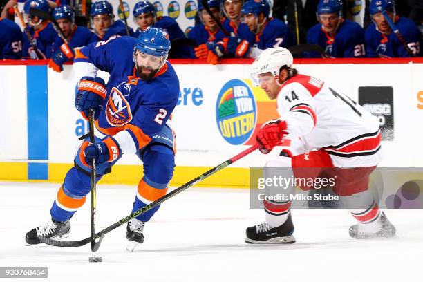 Nick Leddy of the New York Islanders drives with the puck past Justin Williams of the Carolina Hurricanes during the third period at Barclays Center...