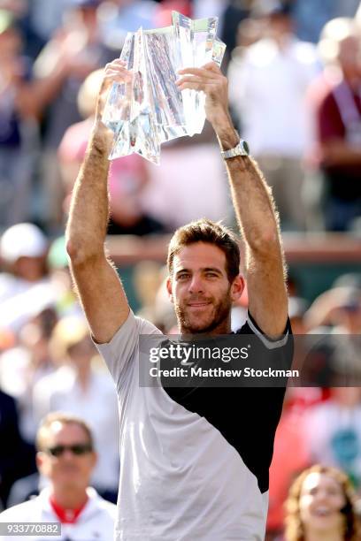 Juan Martin Del Potro of Argentina celebrates with the winner's trophy after defeating Roger Federer of Switzerland during the men's final on Day 14...