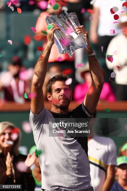 Juan Martin Del Potro of Argentina hoists the winner's trophy after beating Roger Federer of Switzerland in three sets at the BNP Paribas Open on...