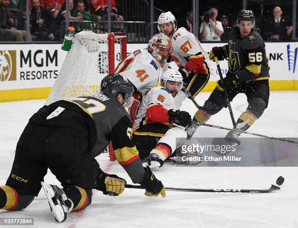 David Perron of the Vegas Golden Knights tries to put a rebound in the net against Mike Smith and Mark Giordano of the Calgary Flames as Michael...