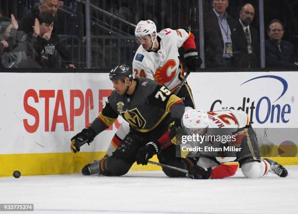 Ryan Reaves of the Vegas Golden Knights goes after a loose puck against Travis Hamonic and Dougie Hamilton of the Calgary Flames in the third period...