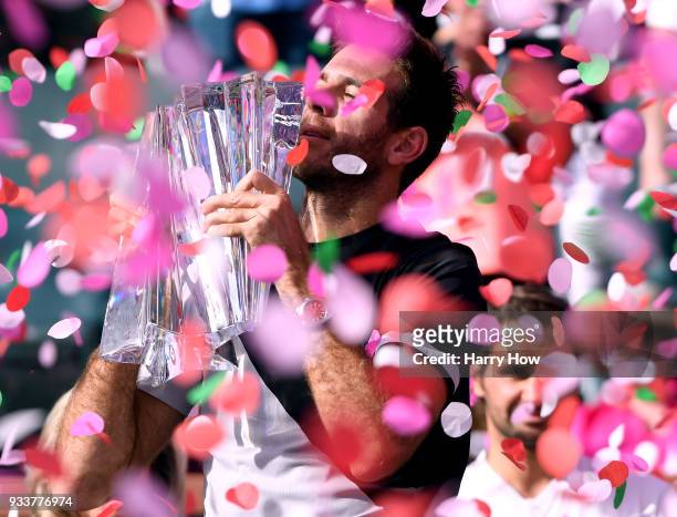Juan Martin Del Potro of Argentina holds up the trophy in front of Roger Federer of Switzerland after his victory in the ATP final during the BNP...
