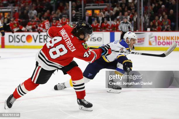 Vinnie Hinostroza of the Chicago Blackhawks fires a shot past Carl Gunnarsson of the St. Louis Blues at the United Center on March 18, 2018 in...