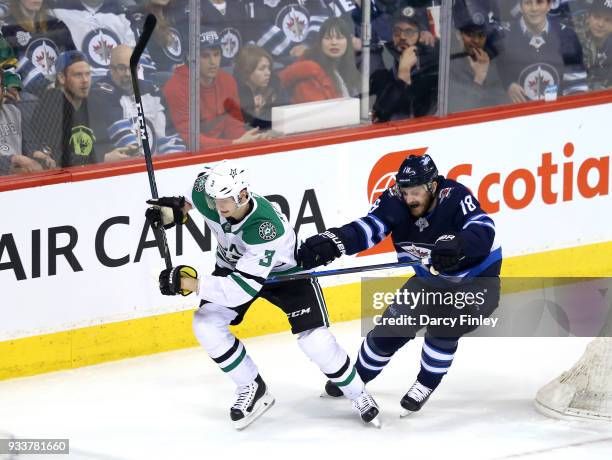 John Klingberg of the Dallas Stars and Bryan Little of the Winnipeg Jets follow the play around the boards during first period action at the Bell MTS...