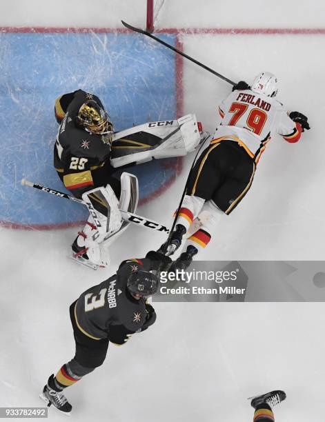Micheal Ferland of the Calgary Flames falls to the ice after trying to put a rebound past Marc-Andre Fleury and Brayden McNabb of the Vegas Golden...