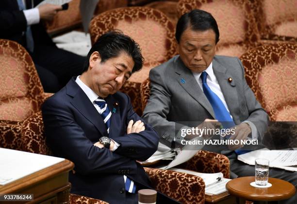 Japan's Prime Minister Shinzo Abe and Finance Minister Taro Aso attend a budget committee session of the upper house in Tokyo on March 19, 2018....