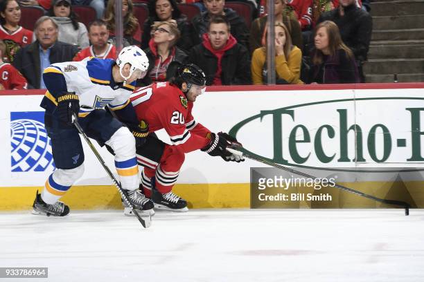 Carl Gunnarsson of the St. Louis Blues and Brandon Saad of the Chicago Blackhawks chase the puck in the third period at the United Center on March...