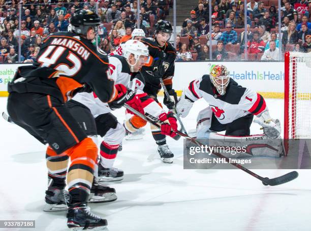 Josh Manson of the Anaheim Ducks and Andy Greene of the New Jersey Devils battle for the puck as Adam Henrique of the Ducks goalie Keith Kinkaid of...