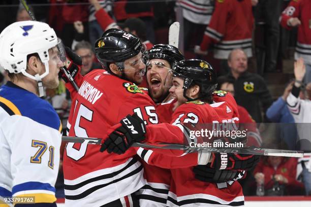 Artem Anisimov, Erik Gustafsson and Alex DeBrincat of the Chicago Blackhawks celebrate after DeBrincat scored in the third period against the St....