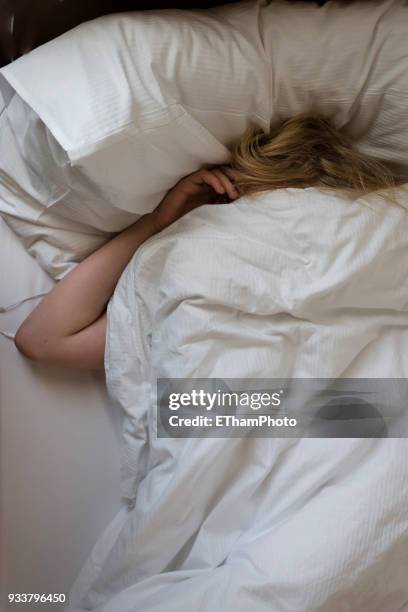 adolescent teenage boy sleeping in his bed - pillow over head stock-fotos und bilder