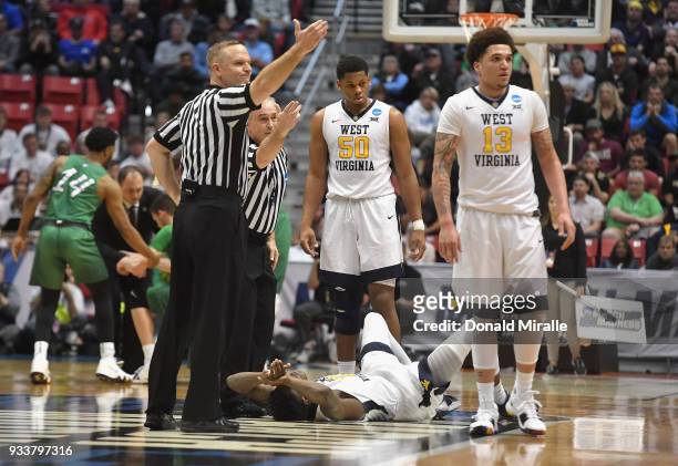 Wesley Harris of the West Virginia Mountaineers lies on the ground after colliding with Jannson Williams of the Marshall Thundering Herd in the first...