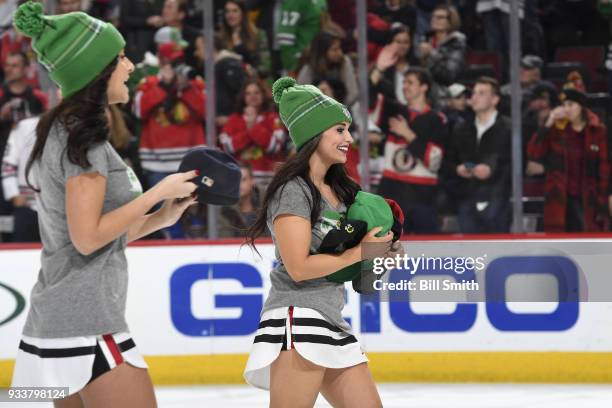 The Chicago Blackhawks ice-crew picks up hats after Alex DeBrincat of the Chicago Blackhawks scored a hat-trick against the St. Louis Blues in the...