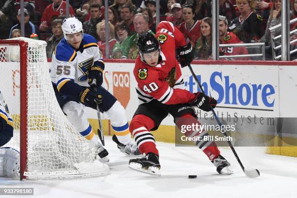 Colton Parayko of the St. Louis Blues and John Hayden of the Chicago Blackhawks chase the puck in the third period at the United Center on March 18,...