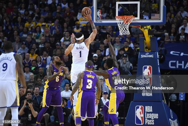 JaVale McGee of the Golden State Warriors shoots over Derrick Williams and Julius Randle of the Los Angeles Lakers during an NBA basketball game at...