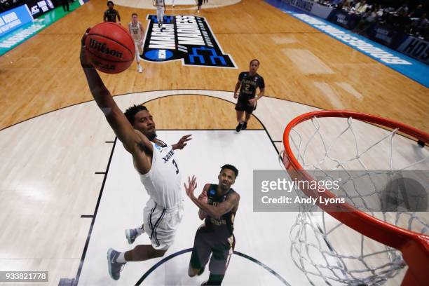 Quentin Goodin of the Xavier Musketeers dunks the ball over Braian Angola of the Florida State Seminoles during the second half in the second round...