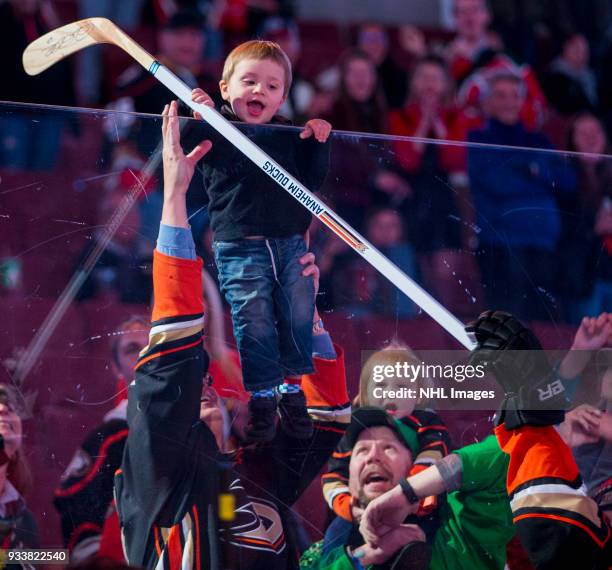 Young fan takes the stick from Rickard Rakell of the Anaheim Ducks as he is announced as the first star of the game after defeating New Jersey Devils...