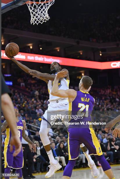 Kevin Durant of the Golden State Warriors goes in for a layup over Travis Wear of the Los Angeles Lakers during an NBA basketball game at ORACLE...