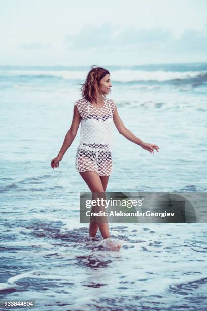 smiling young woman walking in the ocean at the beach - sundress stock pictures, royalty-free photos & images