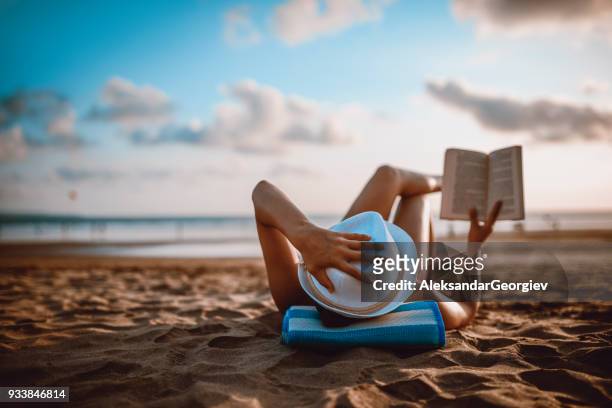 frauen lesen und sonnenuntergang am strand am meer - beach book reading stock-fotos und bilder