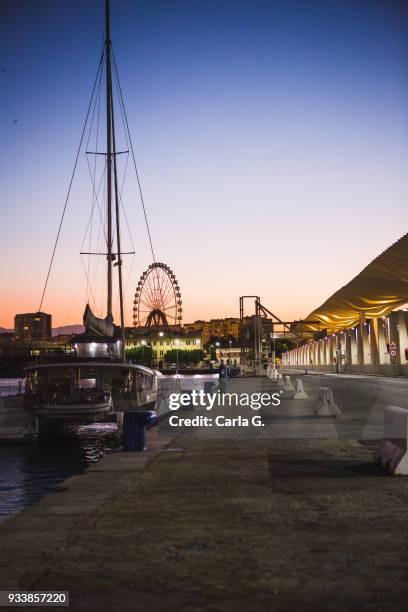 sailboat and ferris wheel in the port of malaga at sunset - muelle stock-fotos und bilder