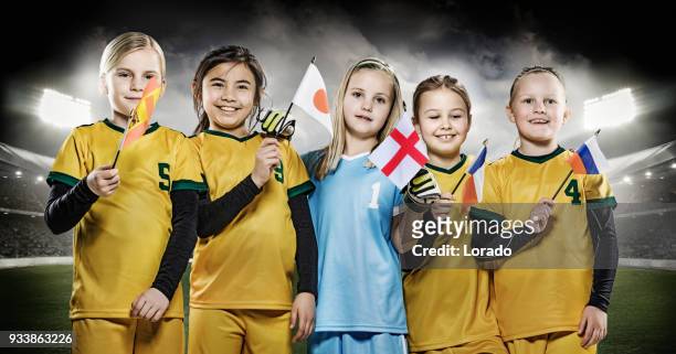 girls football team holding national flags posing for soccer team photo in a floodlit stadium - france national soccer team stock pictures, royalty-free photos & images