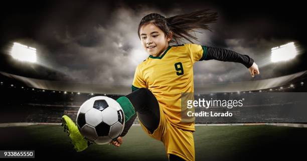 ung flicka fotbollsspelare sparka en fotboll i ett upplyst stadium - försvarare fotbollsspelare bildbanksfoton och bilder