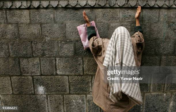 Kashmiri Muslim woman prays outside the wall of the shrine of Khaniqahi mullah on November 24, 2009 in Srinagar, the summer capital of Indian held...