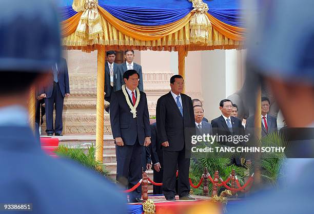 Lao's Prime Minister Bouasone Bouphavanh and Cambodian Prime Minister Hun Sen listen to their national anthems upon Bouphavanh's arrival at the...