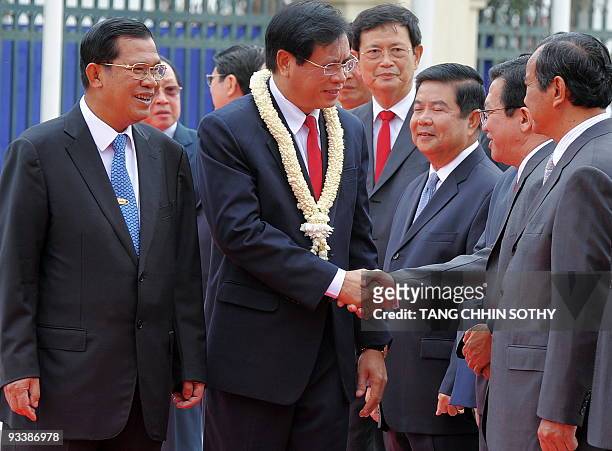 Lao's Prime Minister Bouasone Bouphavanh shakes hands with Cambodian government officials as Prime Minister Hun Sen smiles upon Bouphavanh's arrival...