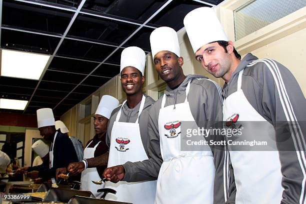 Marvin Williams, Joe Smith, and Zaza Pachulia of the Atlanta Hawks smile for a photo during the Hawks Thanksgiving Event at Gateway Center on...