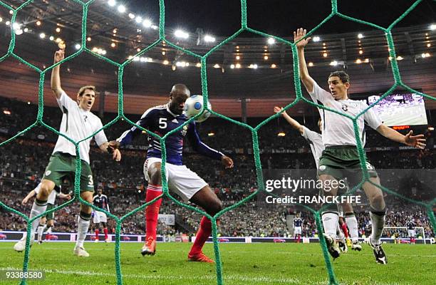 French defender William Gallas scores against Irish forward Keith Andrews and Irish defender Kevin Kilbane during the World Cup 2010 qualifying...