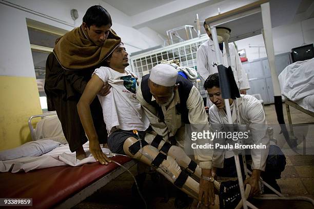 Ezatullah from Jalalabad gets lifted onto the standing table at the International Red Cross Orthopedic rehabilitation center November 23, 2009 Kabul,...