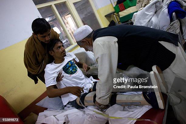 Ezatullah from Jalalabad gets lifted onto the standing table at the International Red Cross Orthopedic rehabilitation center November 23, 2009 Kabul,...