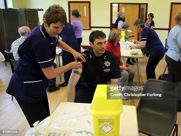 Firefighter is given an innoculation against Swine flu at a medical centre set up in Cockermouth Methodist Church on November 25, 2009 in...