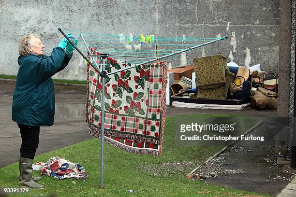 Woman hangs out belongings to dry in the wake of last weeks devastating floods in Cumbria on November 25, 2009 in Cockermouth, England. An army of...