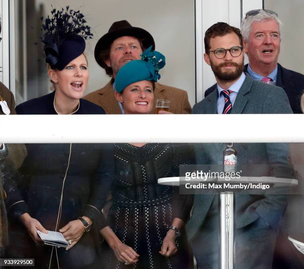 Zara Phillips, Dolly Maude and Jamie Dornan watch the racing as they attend day 4 'Gold Cup Day' of the Cheltenham Festival at Cheltenham Racecourse...