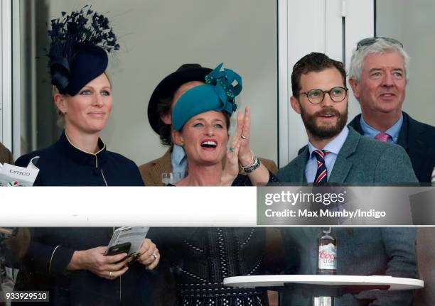 Zara Phillips, Dolly Maude and Jamie Dornan watch the racing as they attend day 4 'Gold Cup Day' of the Cheltenham Festival at Cheltenham Racecourse...