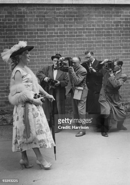Mrs Robert Dumper of Hounslow poses for the photographers at Ascot, 20th June 1956. She is resplendent in a nylon straw hat with tulle trim and a...
