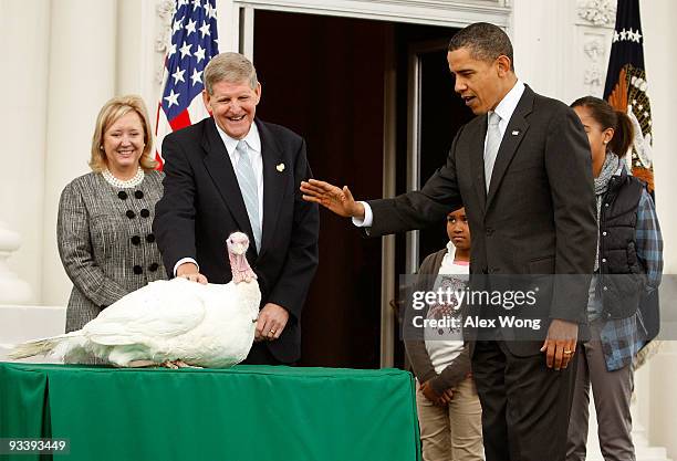 President Barack Obama pardons a turkey named "Courage" as daughter Sasha looks on during an event to pardon the 20-week-old and 45-pound turkey at...