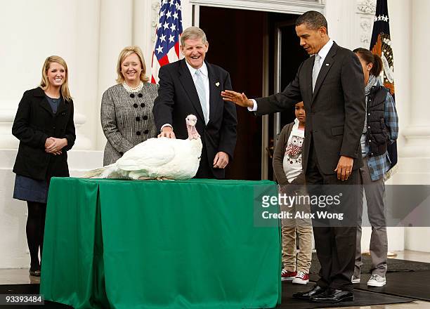President Barack Obama pardons a turkey named "Courage" as daughter Sasha looks on during an event to pardon the 20-week-old and 45-pound turkey at...