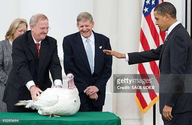 President Barack Obama waves his hand as he pardons a turkey named Courage during the annual turkey pardoning ceremony for Thanksgiving on the North...