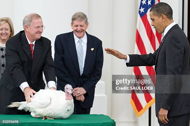 President Barack Obama waves his hand as he pardons a turkey named Courage during the annual turkey pardoning ceremony for Thanksgiving on the North...